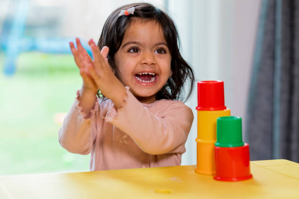 A toddler girl is seen laughing and clapping